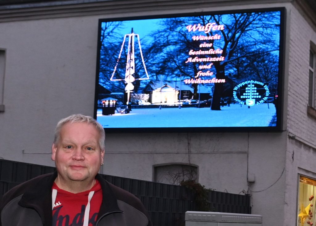 Reiner Schulze-Tenberge, der 1. Vorsitzende des Wulfener Wappenbaumvereins an der B 58 in Wulfen vor der digitalen Anzeigenwand / Foto: Bludau